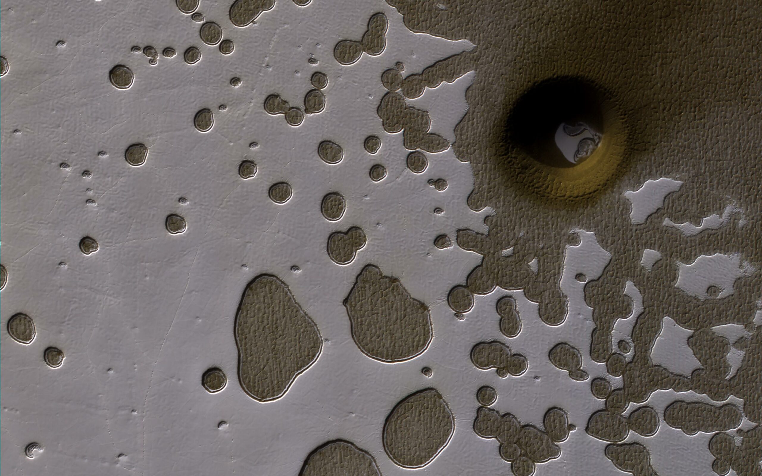 Камера HiRISE на апараті NASA Mars Reconnaissance Orbiter зафіксувала цю незвичну яму на поверхні Марса