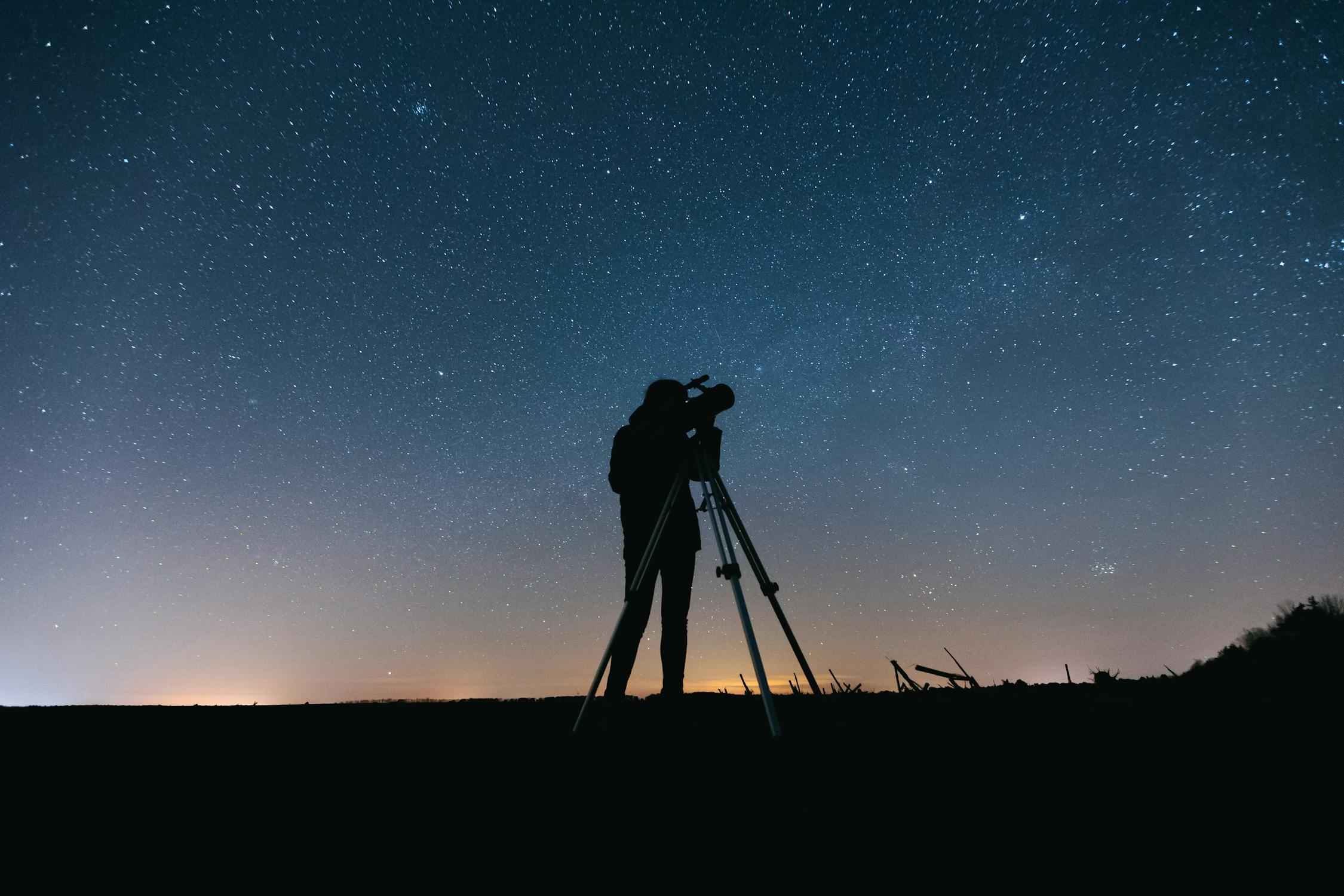 Cloudy Night Sky. Silhouette of Person Standing on a Field Under Starry Night.
