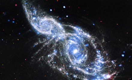 Злиття спіральних галактик NGC 2207 та IC 2163 у рожевих рентгенівських та біло-червоних інфрачервоних кольорах.