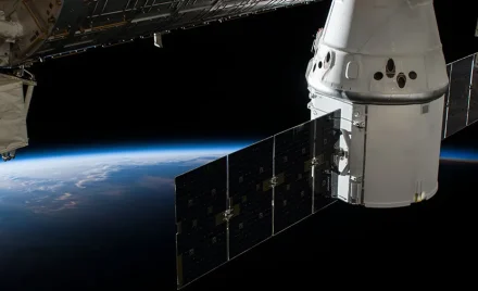 Вантажний корабель SpaceX Dragon пристикований до модуля Harmony МКС на тлі Землі